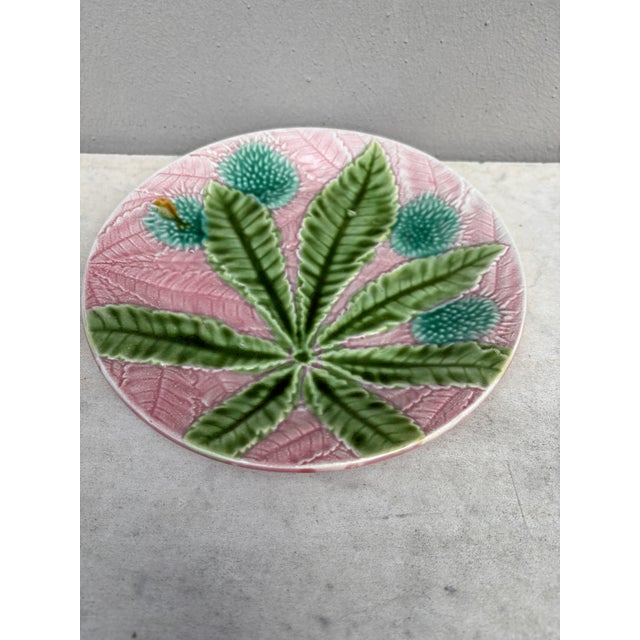 Majolica chestnut leaves plate Salins, circa 1880, on a pink background.