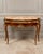 Elegant French Louis XV-style console table featuring a luxurious marble top, richly figured wood construction and...