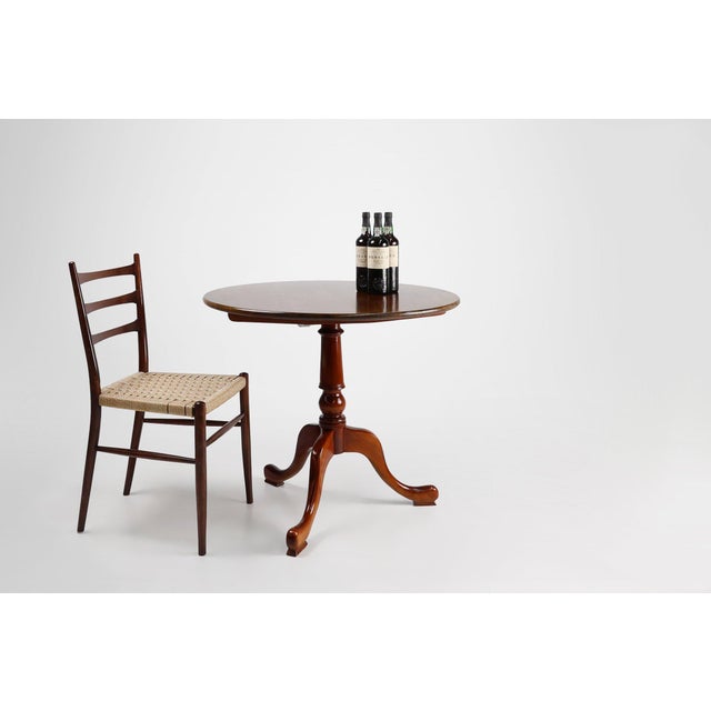 An elegant English tilt-top occasional table crafted in solid cherry wood, dating from around 1950. Combining traditional...
