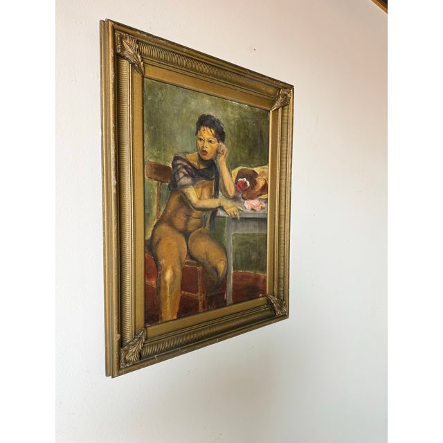 A captivating and intimate portrayal of a nude woman seated in quiet contemplation, this vintage oil painting dates back...