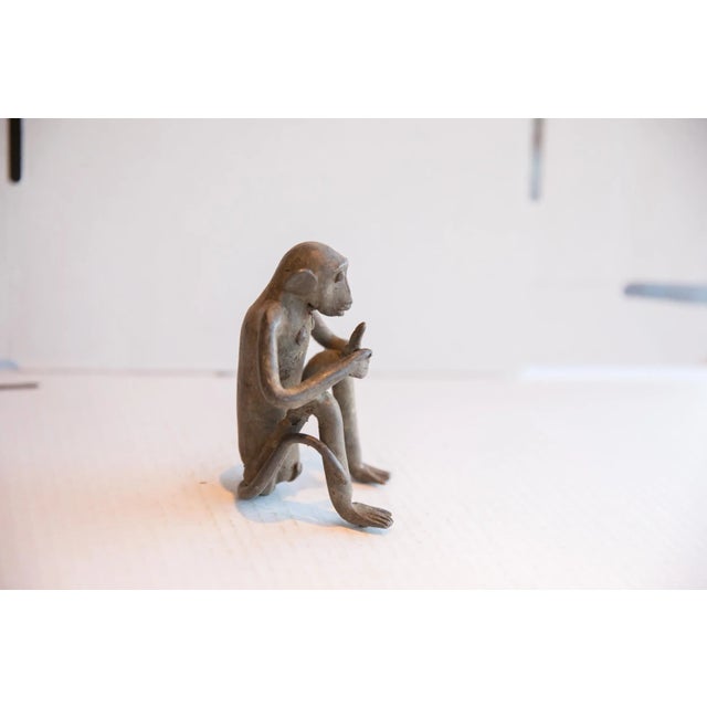 :: Vintage handmade African sitting monkey with banana sculpture. Circa late mid 20th century, though possibly older, this...