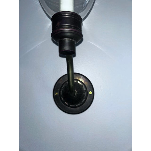 Based on an original hurricane candle lamp, this storm wall light has decorative acanthus leaf decoration on its circular...