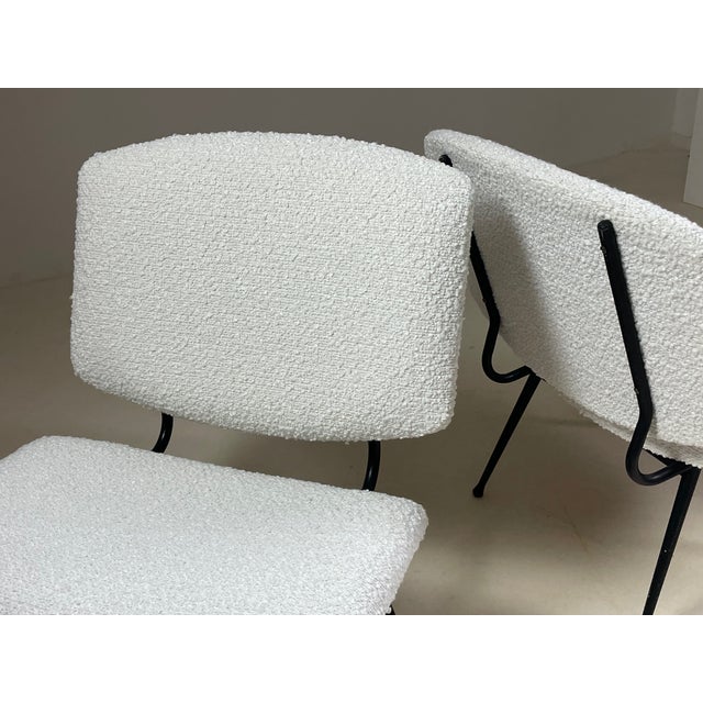 Pair of armchairs made in France in the 1950s. Black metal frame with some signs of wear visible in the photos. The seats...