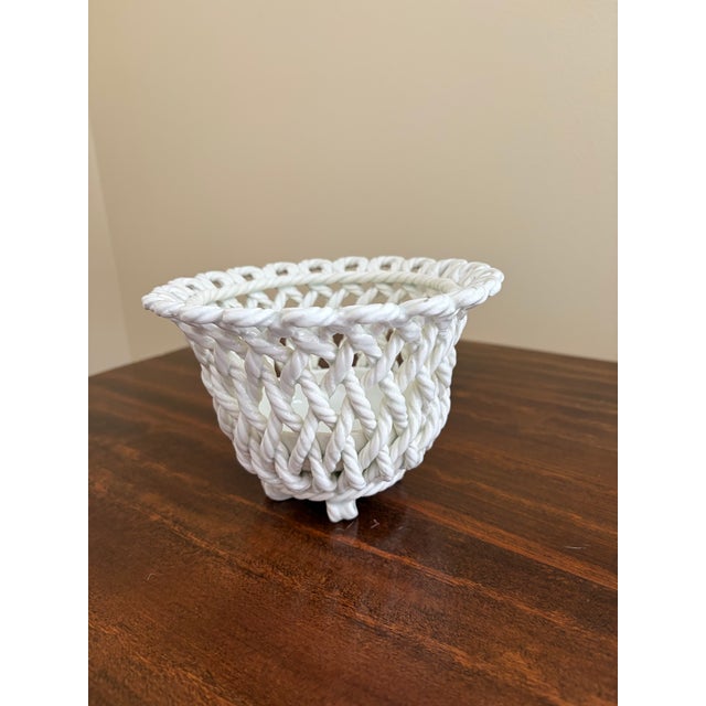 An elegant trompe l'oeil porcelain cachepot crafted in the form of a handwoven rope basket. Executed in glossy white...