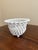 An elegant trompe l'oeil porcelain cachepot crafted in the form of a handwoven rope basket. Executed in glossy white...