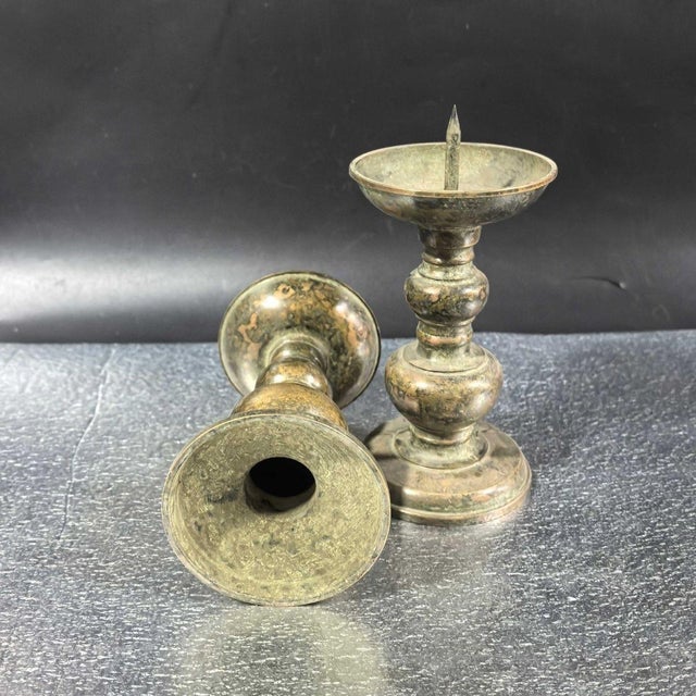 A lovely matching pair of Chinese bronze pricket candlesticks. Each candlestick features tiered gourd-form stems, a wide...