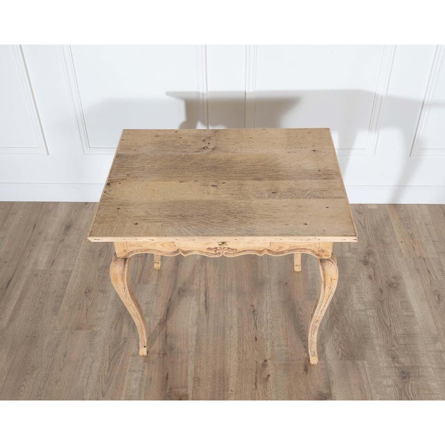 A charming Louis XV style writing table from the 19th century, crafted in warm natural oak. The rectangular top displays a...