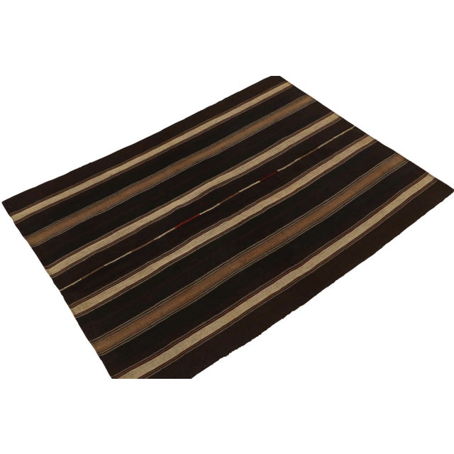 Handwoven in wool, a 5x7 vintage Turkish kilim rug originating circa 1950-1960, connoting a distinctive mid-century...