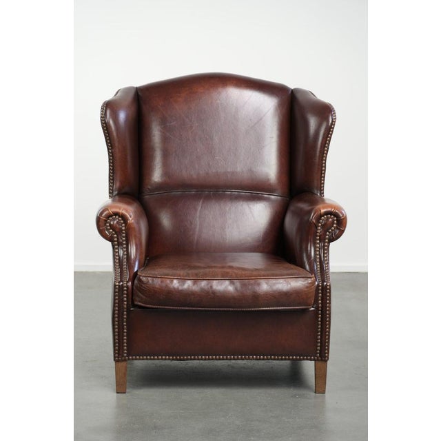 Offered by ByThijs: this elegant vintage sheepskin wing armchair with a timeless English look, finished with decorative...