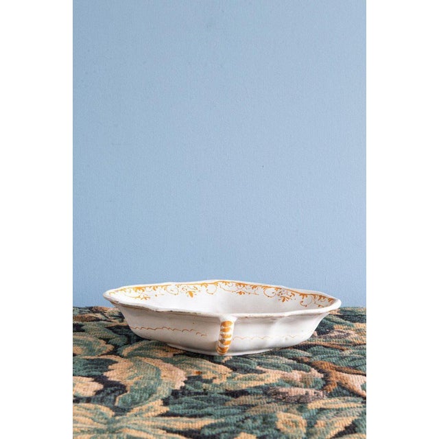 This 18th-century faience sauceboat from Southewestern France is decorated with elegant flowers and a delicate frieze of...