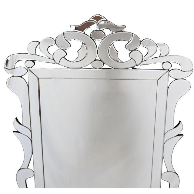 Elegant wall mirror with an ornate surround formed from shaped mirrored glass. Flowing scrolls and stylised leaf motifs...