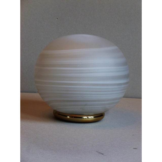 A Murano glass table lamp by VeArt, designed by Ludovico Diaz De Santilliana, in the shape of a slightly flattened globe...