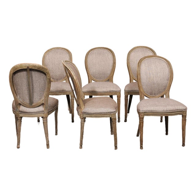 A French set of 6 Louis XVI style, oval-back upholstered side chairs from the 19th century. These antique chairs from...