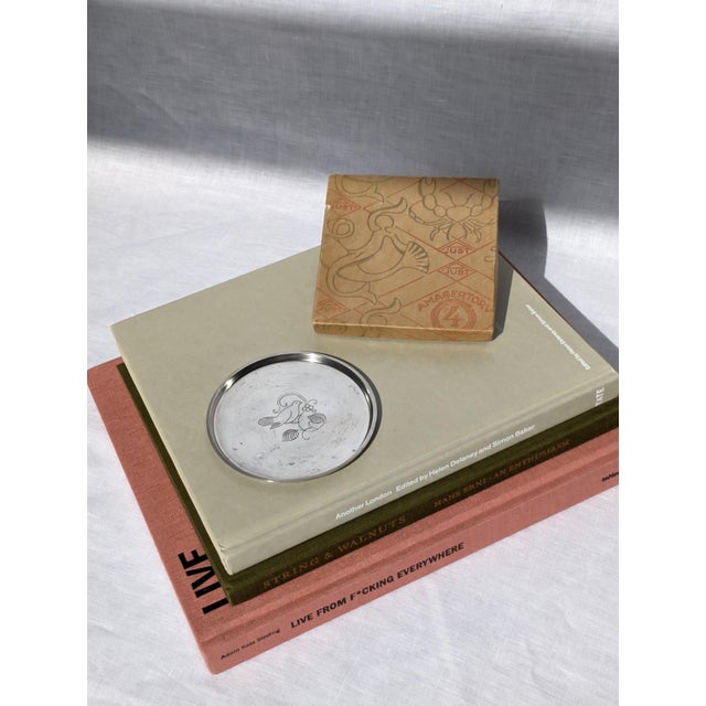A vintage Just Andersen engraved pewter bottle coaster made in Denmark circa 1930. This chic art deco style silver metal...
