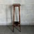 A slender and elegant two-tiered wooden pedestal column, a refined interior design piece attributable to 1960s Italian...