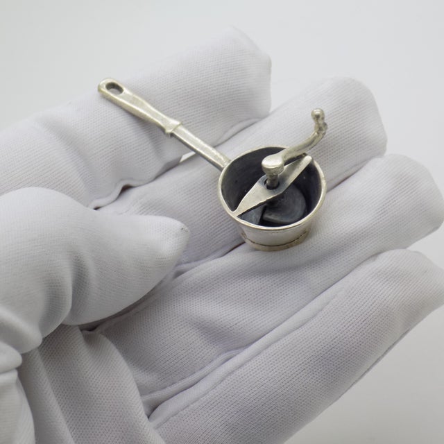 This vintage silver decorative object depicts a traditional food strainer mill passapomodori miniature, crafted as a...