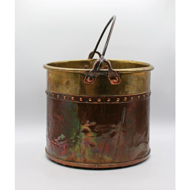 Circa 1880 English copper & brass large bucket. Iron swing handle with copper handle brackets. Decorative rivets create...