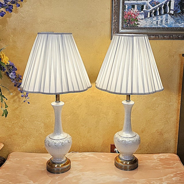 This refined pair of vintage white crackle-glaze table lamps offers tall, elegant silhouettes with gently flared ceramic...