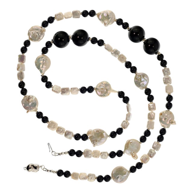 This is part of Chairish’s Fine Jewelry assortment. This is a lovely, long white Coin Pearl and Black Onyx necklace that...