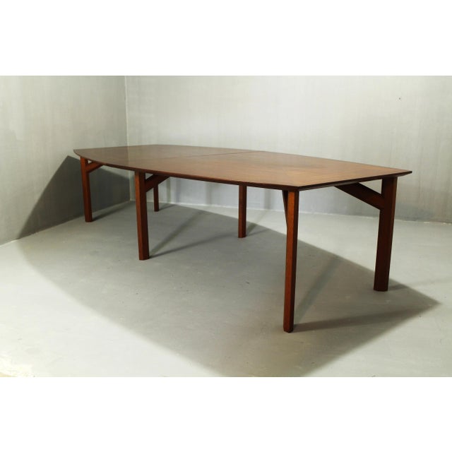 Large teak table; the legs are made of solid teak, and the tabletop is teak-veneered. The leg mounts have been...