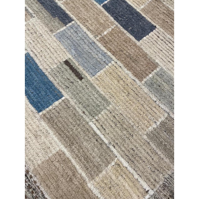 Elevate your space with this stunning modern handmade Moroccan-style wool rug. Its captivating geometric design, adorned...