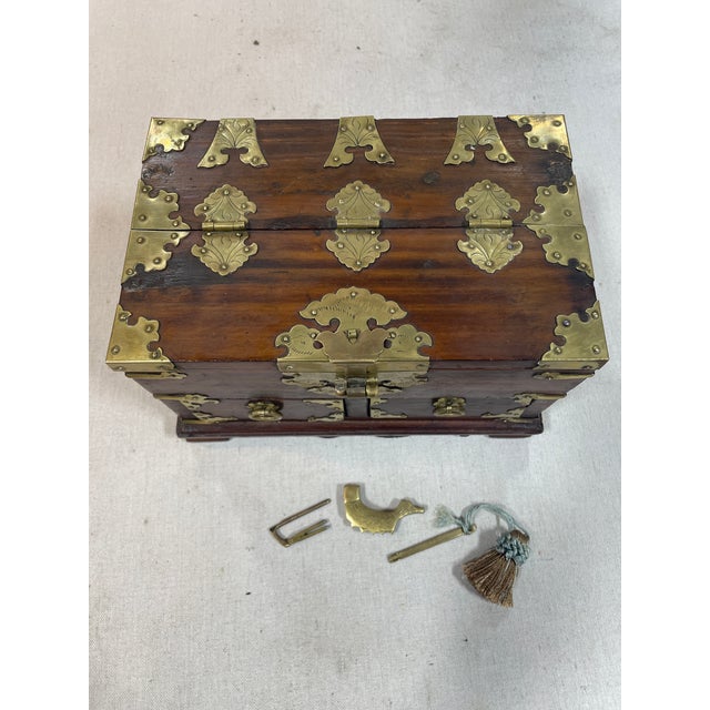 Rosewood with brass detailing. Lined with original paper. Coy fish lock with 2 keys.