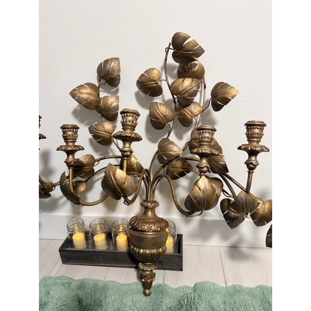 A dramatic oversized vintage wall candelabra with sculptural metal leaves, vine-like branches, and an antiqued gold...