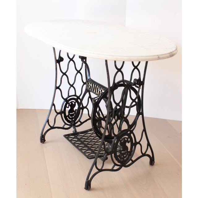 Early 20th Century SINGER treadle sewing machine console, made of cast iron. The singer base was paired with a timeless...