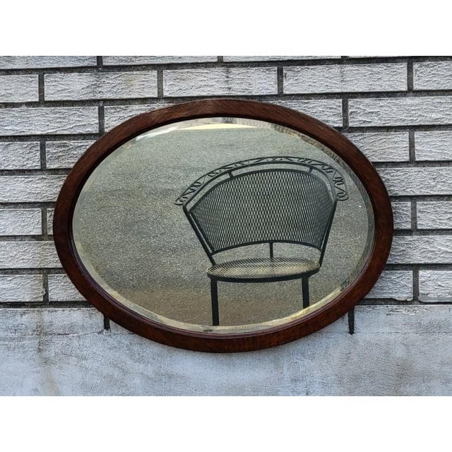 Beautiful antique Victorian oval wall mirror with a solid oak frame and original beveled edge glass. Features attractive...