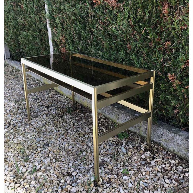 Brass structure, smoked glass shelves. This piece is attributed to the mentioned designer/maker. It has no attribution...