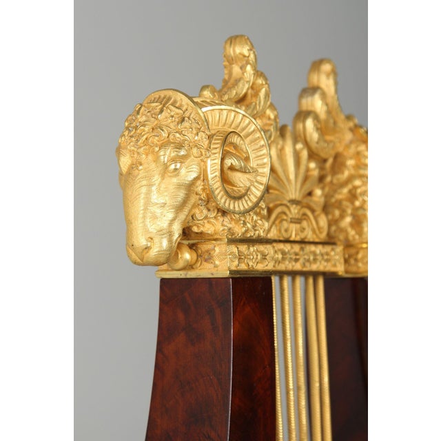 Large lyra pendulum clock with ram’s heads france mahogany, bronze c. 1825 dimensions: h x w x d: 59 x 28 x 15 cm a large...