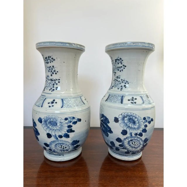 This is a beautiful pair of chinoiserie blue and white vases with Greek Key motif around the top edges as well as cherry...