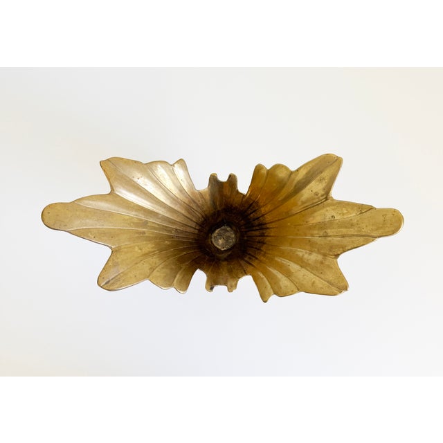 A striking mid-century Hollywood Regency-style, aged brass winged centerpiece bowl. It features a dramatic, sculptural...