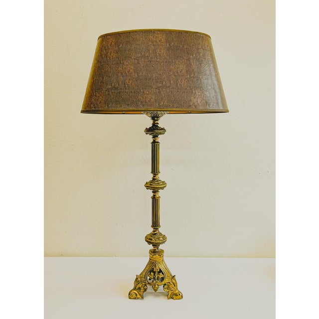 An elegant bronze table lamp French Renaissance style, early 1900s. Ornately designed on a triangular openwork base and...