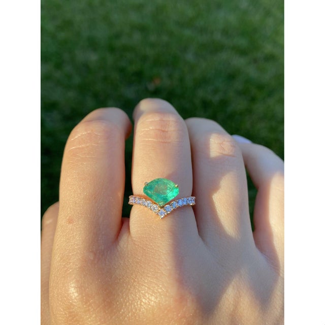 Unique kite shape natural Colombian Emerald, mounted in 18k rose gold and set on a curved regal band with luminous natural...