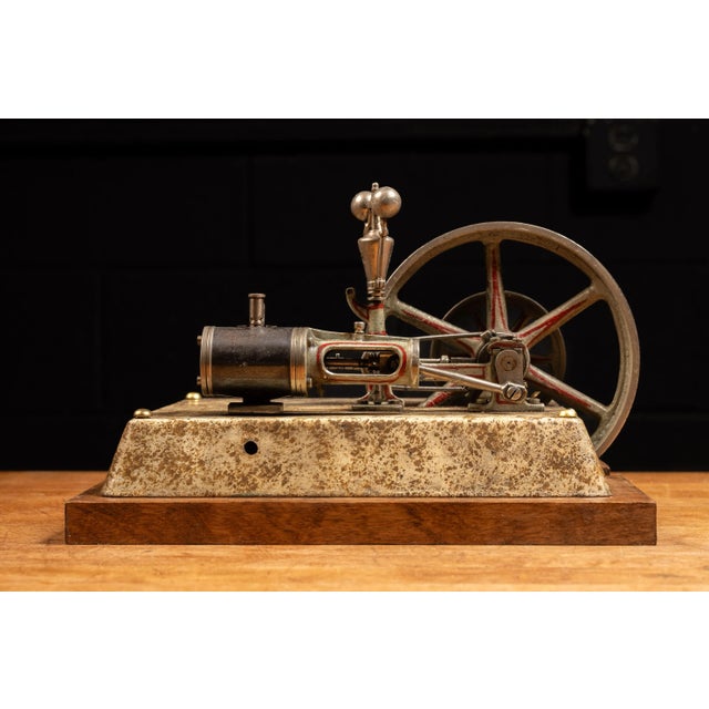 A tabletop model steam engine, mounted on a wooden block to allow the engine and it's mount to sit properly. All parts...