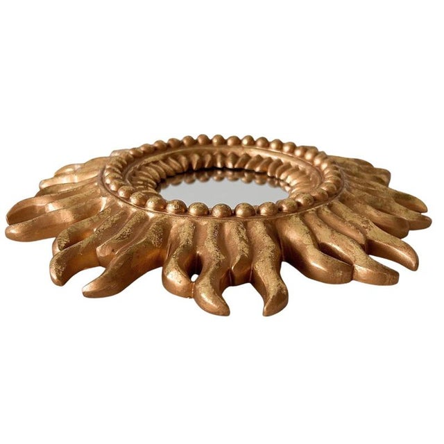 This vintage gold sunburst mirror from the 1980s is perfect for a Hollywood Regency interior. The gold mirror has a gold...