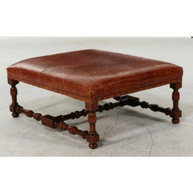 This oversized cocktail ottoman by Ralph Lauren Home is expertly upholstered in a rich, cognac-colored crocodile-embossed...
