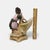 This elegant porcelain figurine features a Victorian-style woman in a graceful pink and green gown, leaning against a...