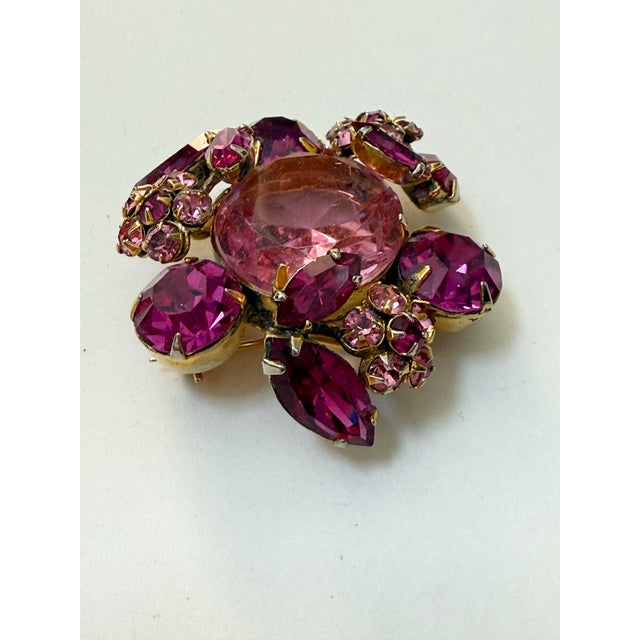 This fabulous Regency brooch features a tiered, high-dome design with a large, faceted pastel pink crystal center stone...