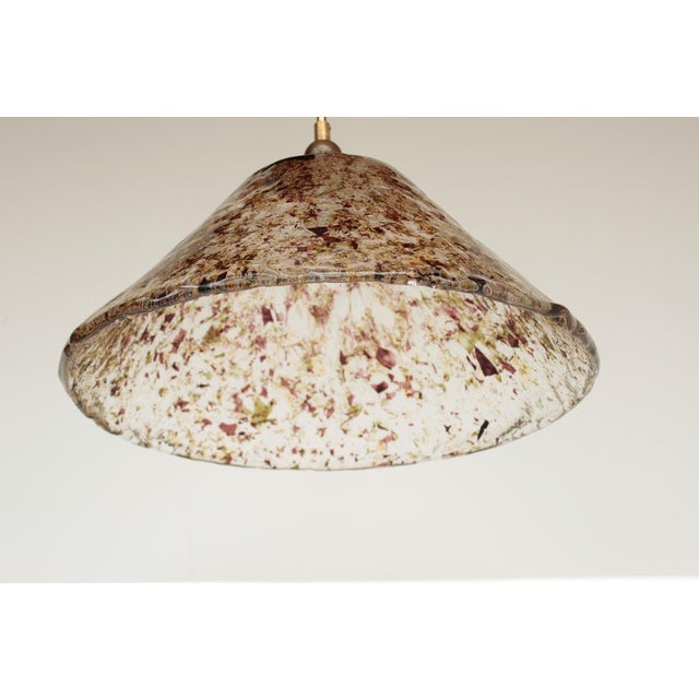 Heavy murano glass pendant light on a brass fixture. transparent glass with colorful glass insets. the light requires one...