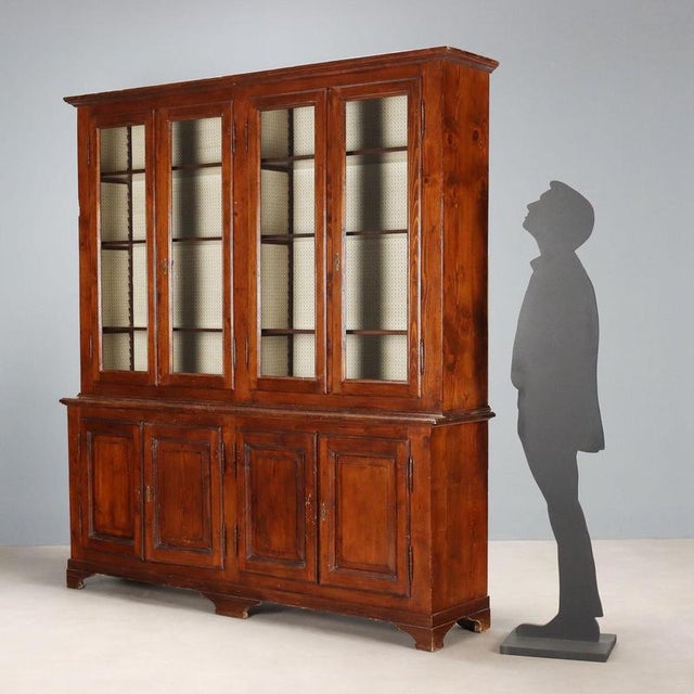 Walnut-stained fir bookcase. Upper section with four glass doors, three height-adjustable internal shelves with a rack....