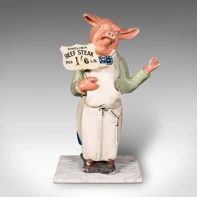 This is an antique butcher's shop display figure. An English, plasterwork commercial advertising pig in uniform on marble...