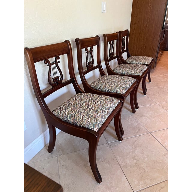 Four Vintage Mid Century Wood Chairs with fabric seats. The back of the chair is similar to a lyre harp instrument. The...