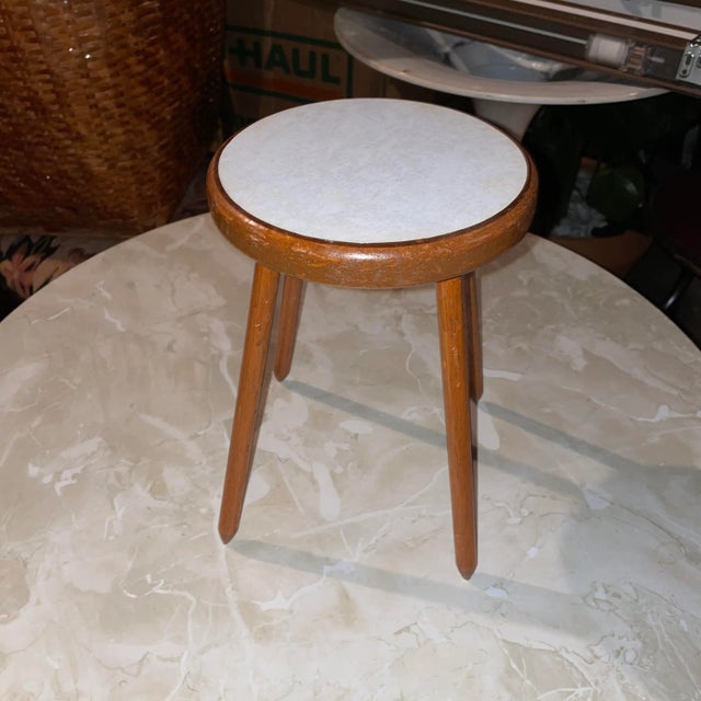 1970s Pencil Legged Plant Stand With Formica Top. The item is in great condition. Wooden legs and Formica top.