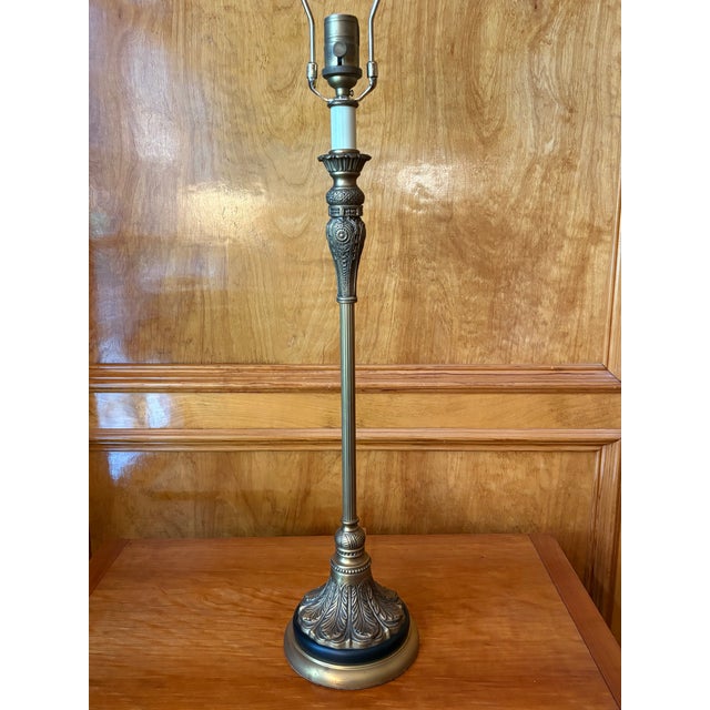 This elegant and slender Bombay Company lamp in the neoclassical style features a rich matte brass finish with black...