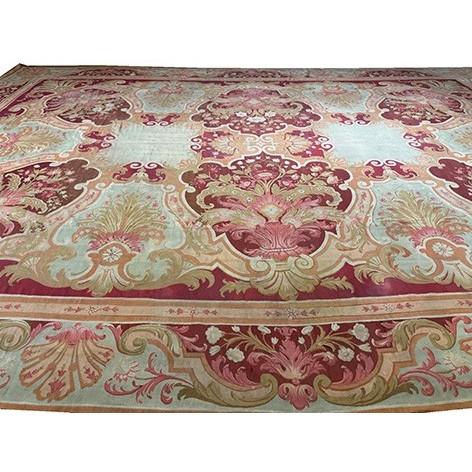 This circa 1840 French Antique Aubusson rug is a flat-woven tapestry piece featuring a vibrant red field with a soft blue...