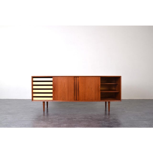 This teak sideboard was made in Denmark in the 60s. This piece of furniture has two sliding doors and two lockable doors....