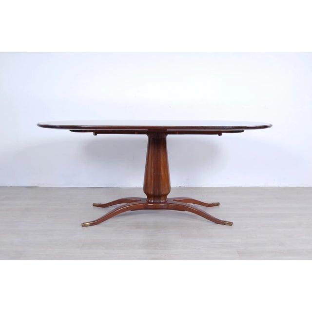 Mid-Century table in wood, oval top with interlocking glass. Attractive design reminiscent of the style of Paolo Buffa....
