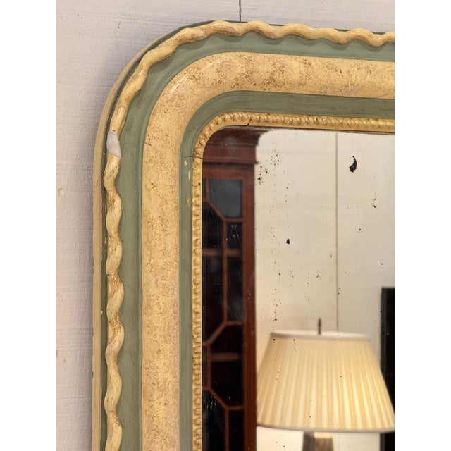 A Louis Philippe mirror with a sage green and gilt frame, wavy outer molding, and beaded inner border. Original mirror plate.